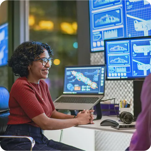 Lady sitting at the computer reviewing energy data.