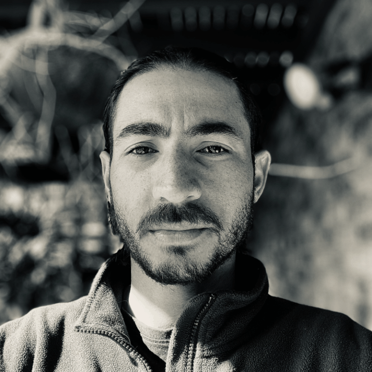 a man smiling at the camera in a jacket