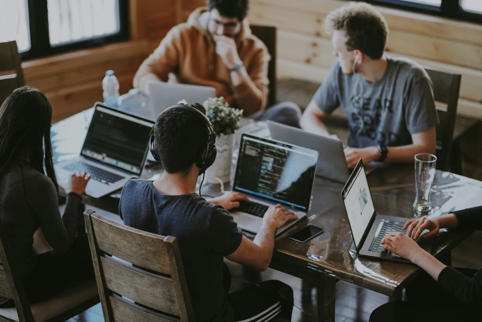 Team of workers around a table on their laptops