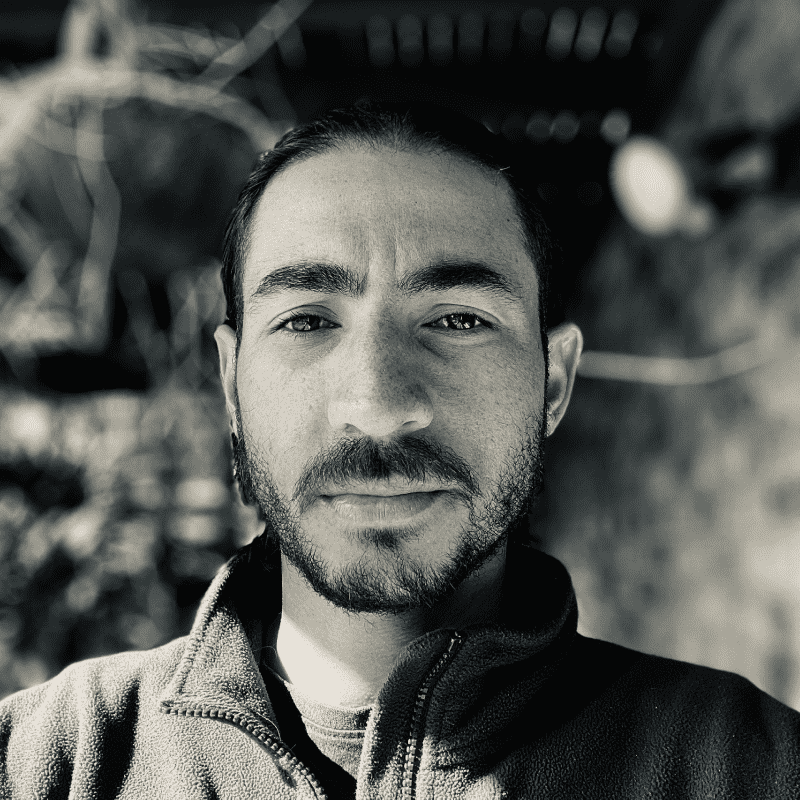 a man smiling at the camera in a jacket